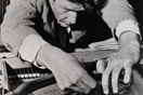 John Cage preparing a piano 132x88