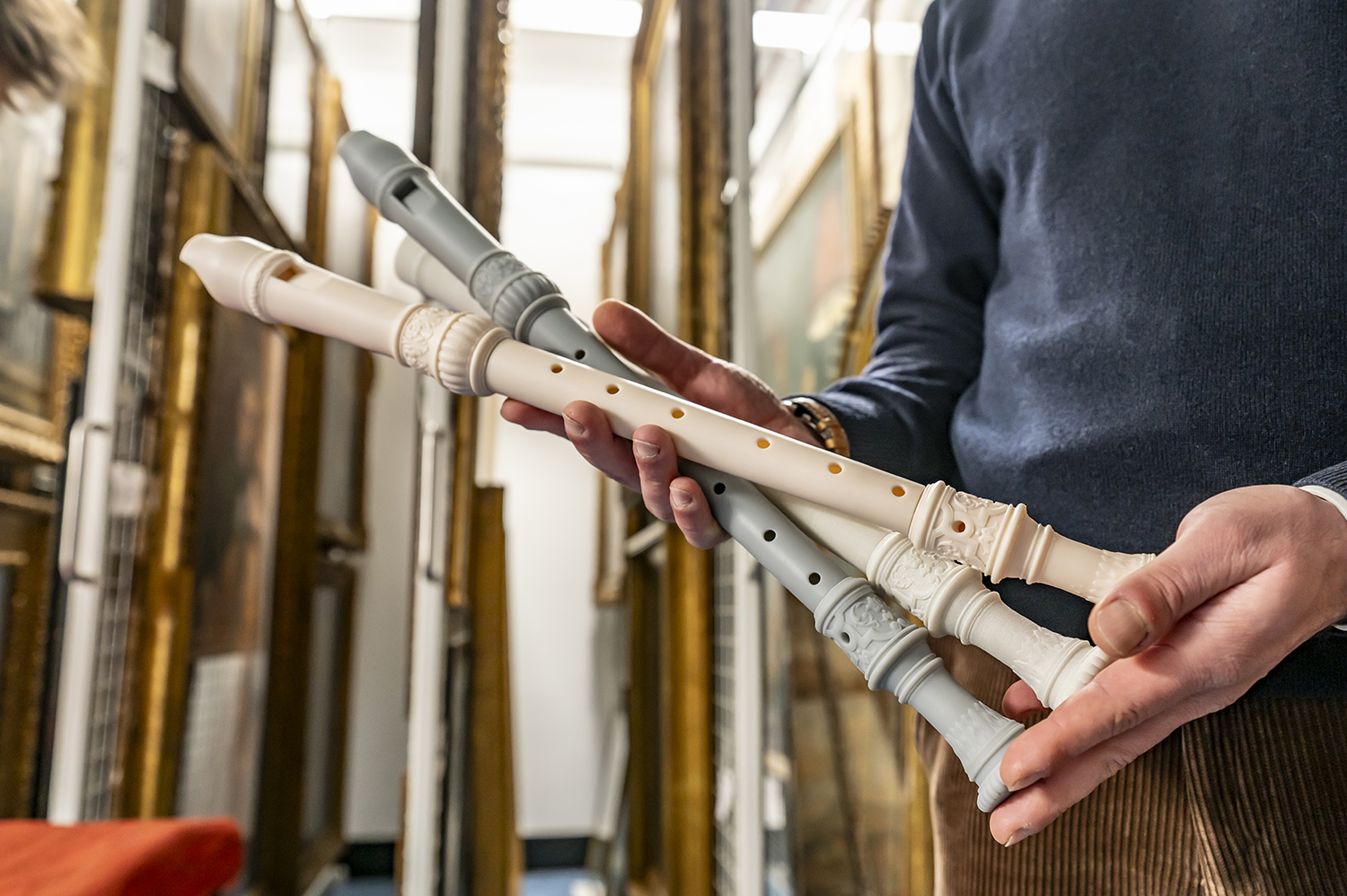 A close up image of someone holding three 3d printed recorders