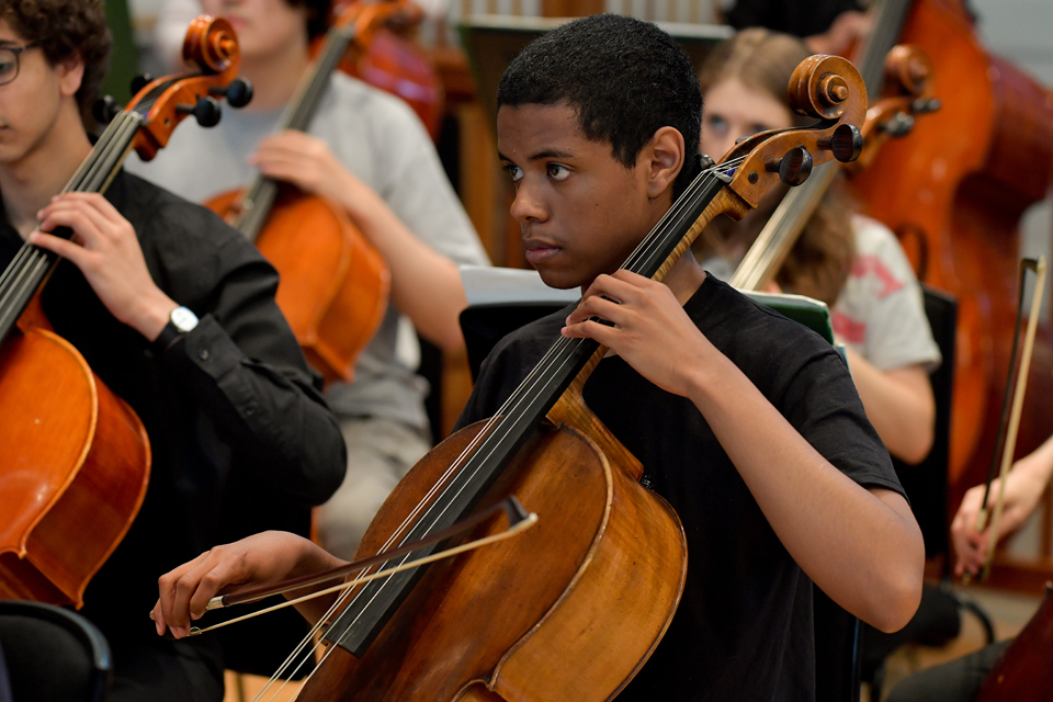 A young cellist performs with an RCM Junior Department orchestra