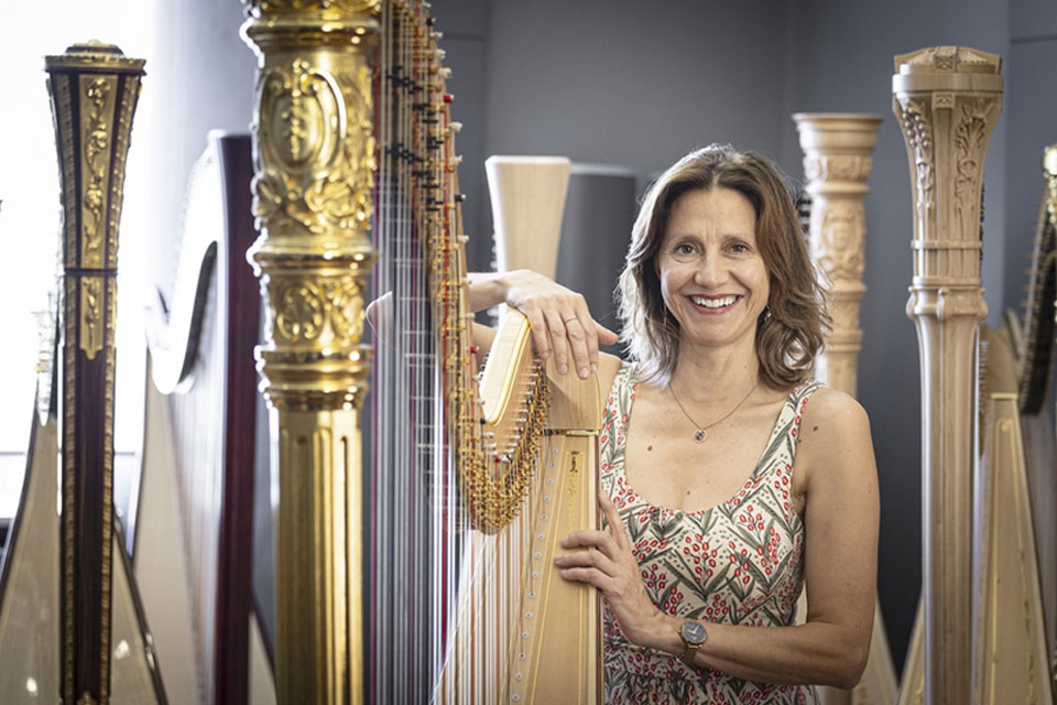 Sandrine Chatron stands amongst harps and smiles