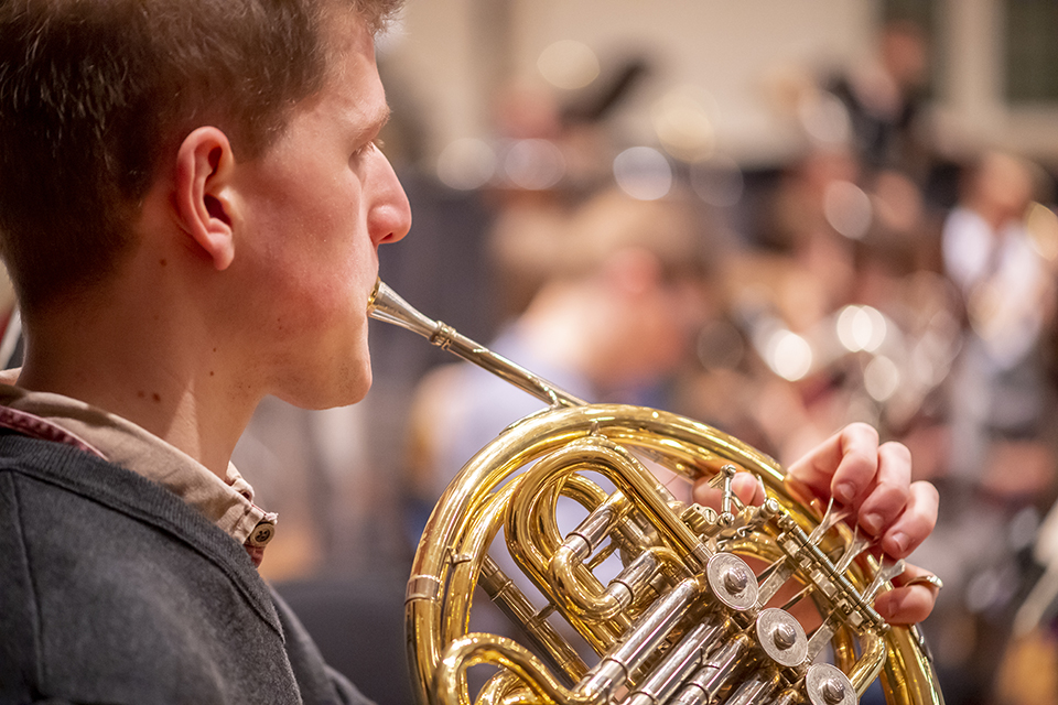 A close up of a French horn player performing