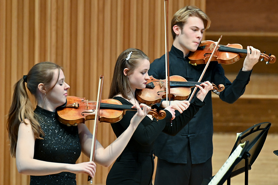 Three violinists performing