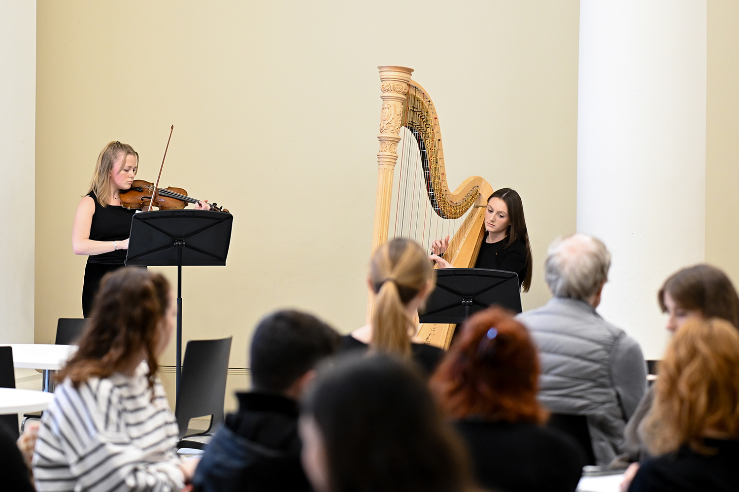 A flautist and a harpist performing during a chamber concert