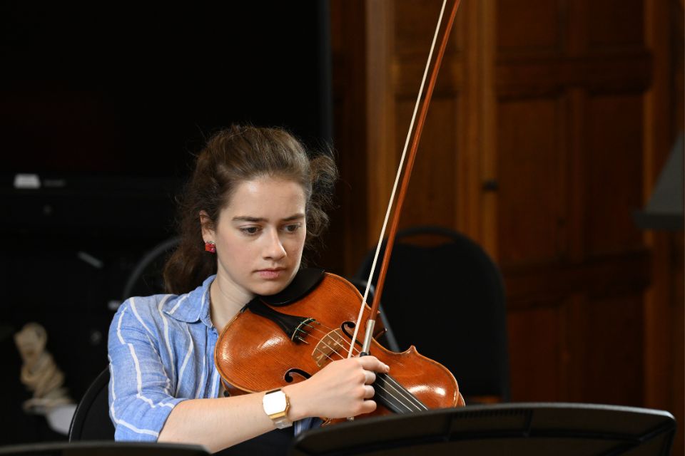 A young woman plays the viola