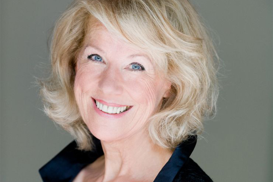 Edith Wiens smiles at the camera, with a green background