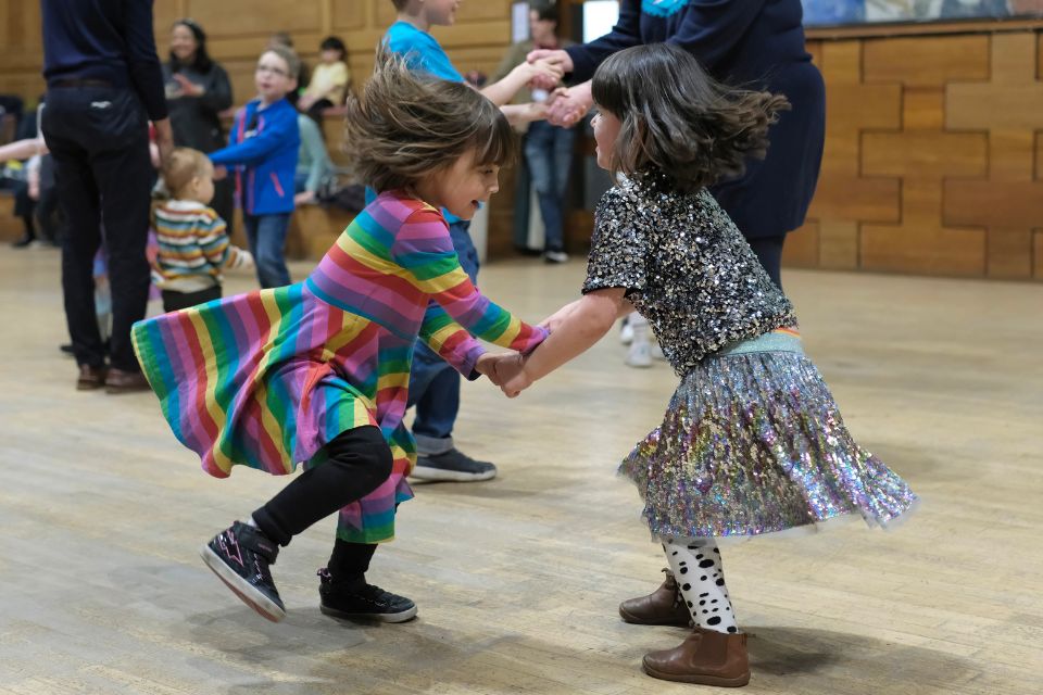 Two children dance together and smile