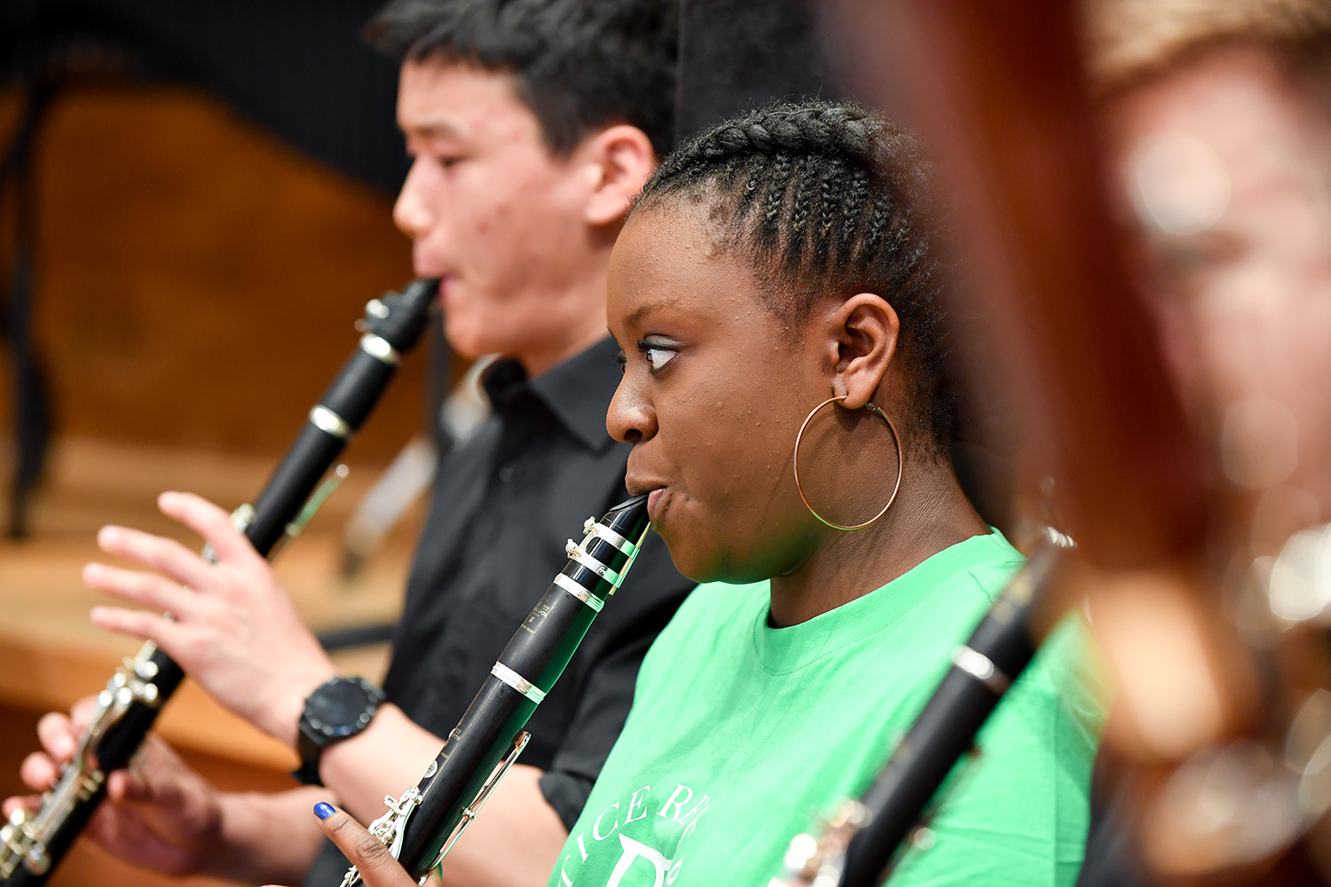 A JD student wearing bright green performs on a clarinet