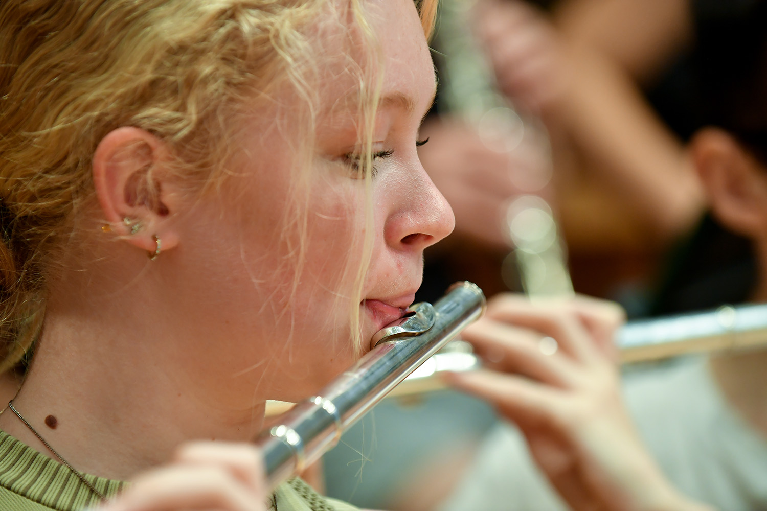 A close up image of a JD student performing on the flute