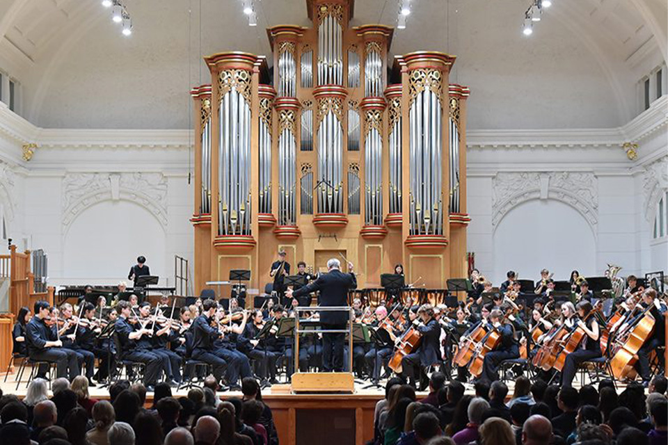 A large orchestra performs on stage