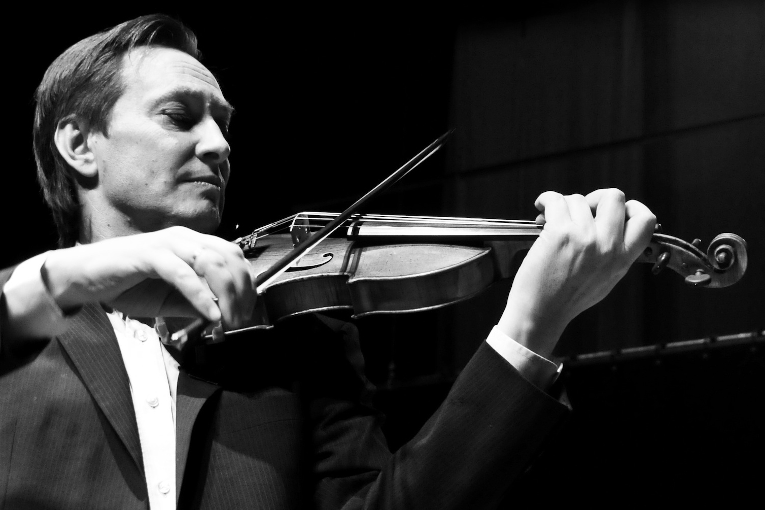 A black and white image of a man playing the violin