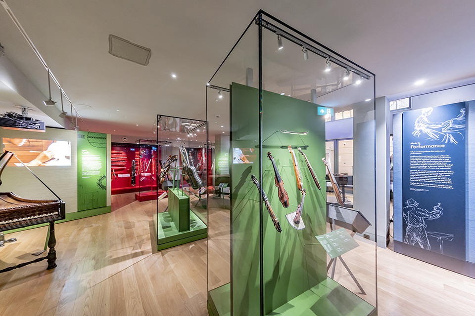 Display cases in the RCM Museum containing historic stringed instruments