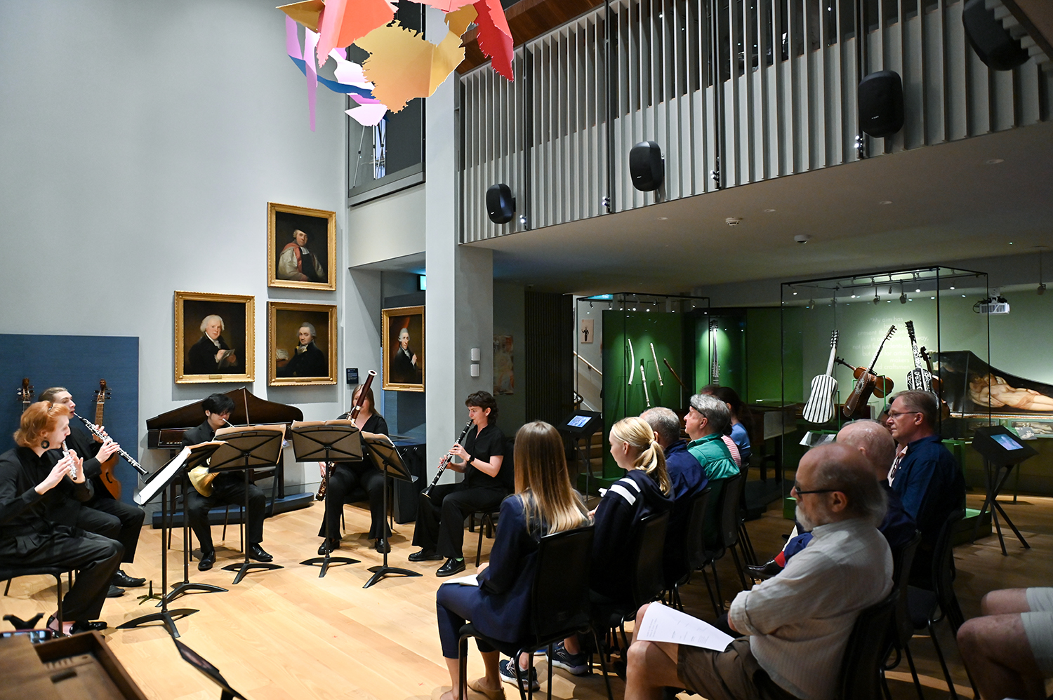 Musicians performing to a busy audience in the RCM Museum