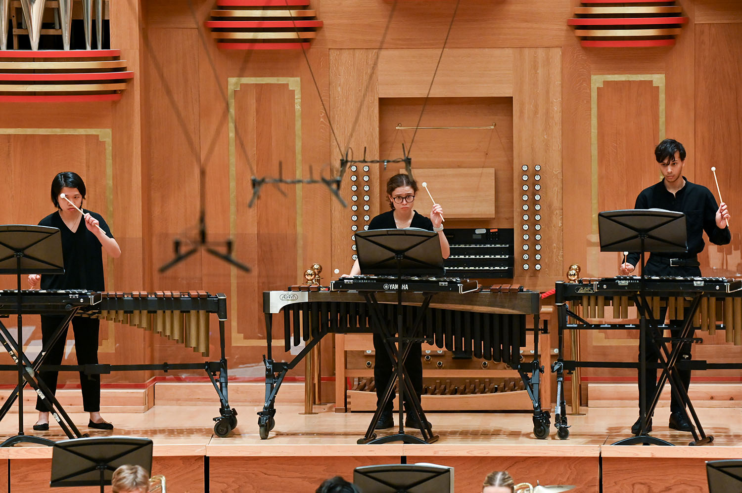 Three percussionists performing on the Amaryllis Fleming Concert Hall stage 
