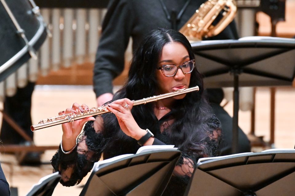 A flautist plays her instrument on stage