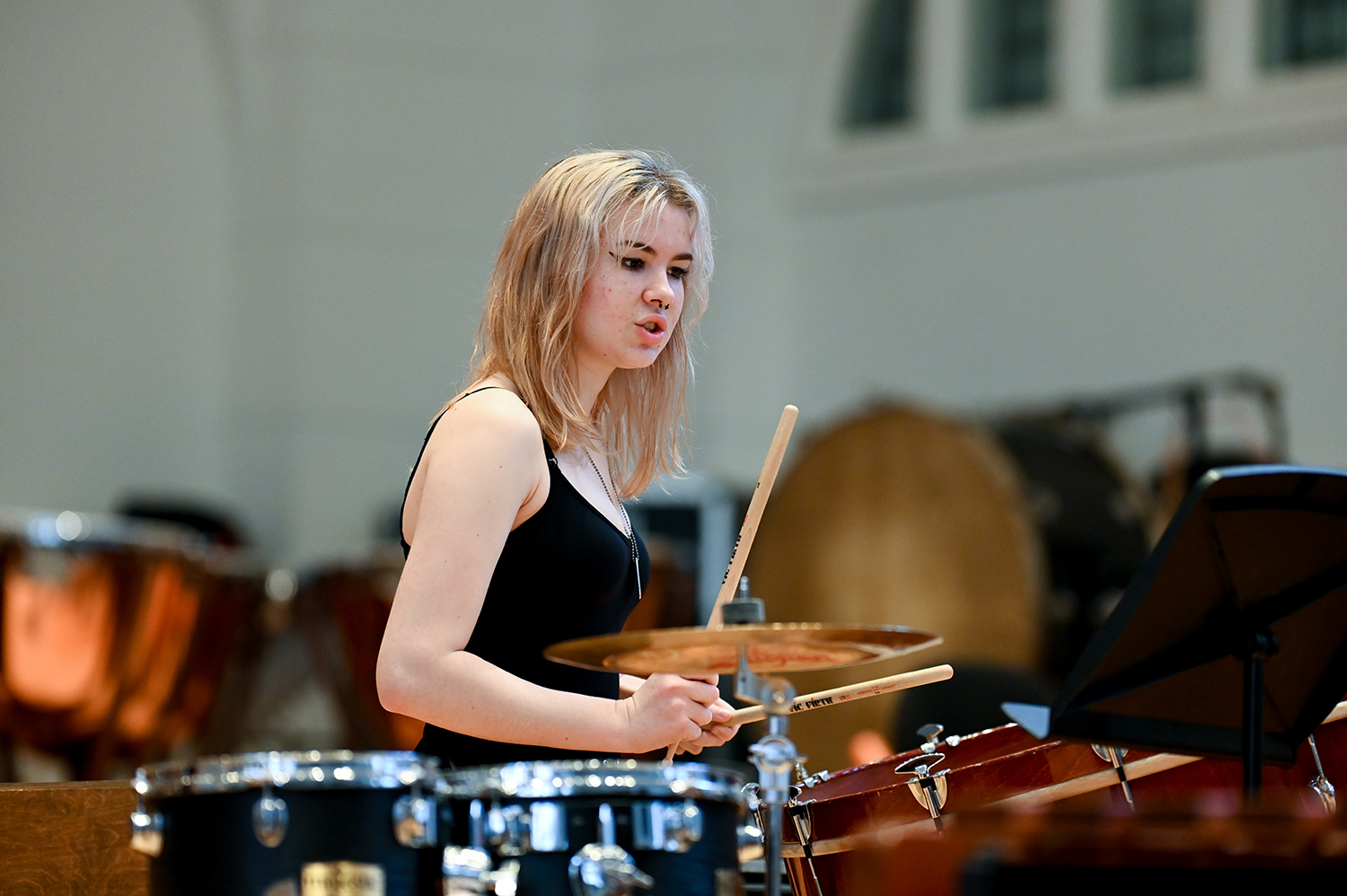 A woman with a black top playing the drums