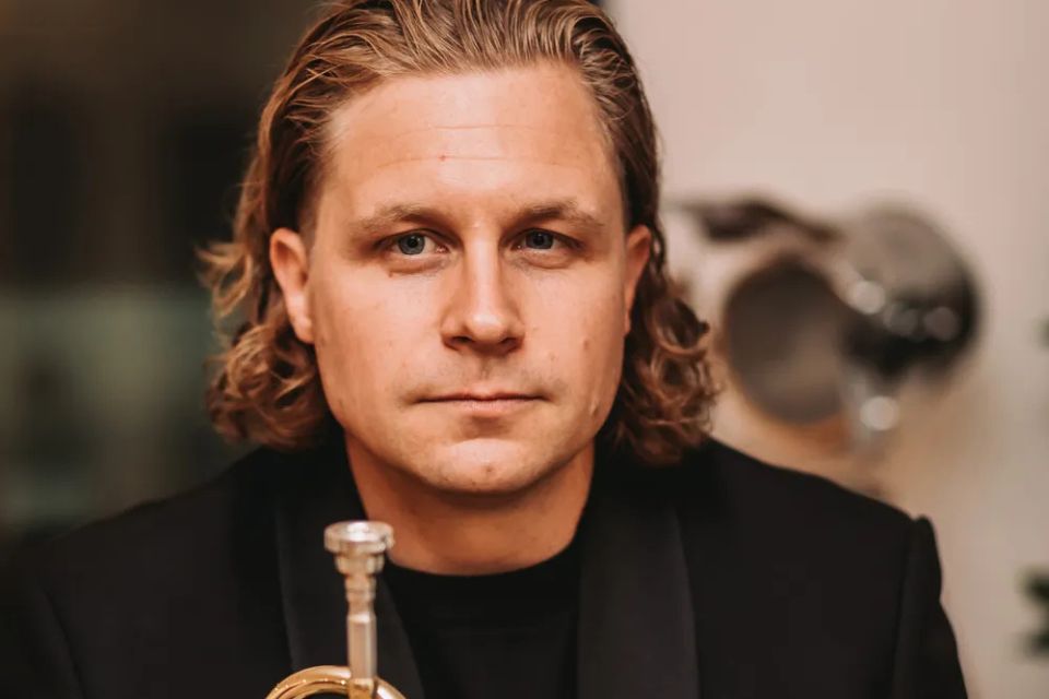 Philip Cobb holds his trumpet and smiles