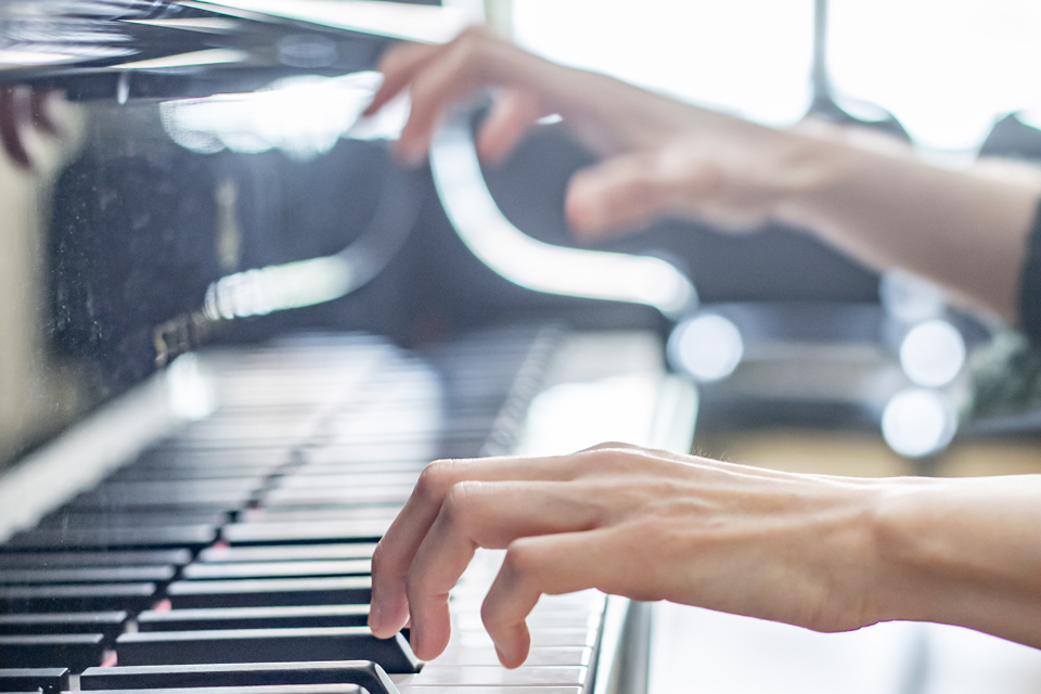 A close-up photo of hands at the piano