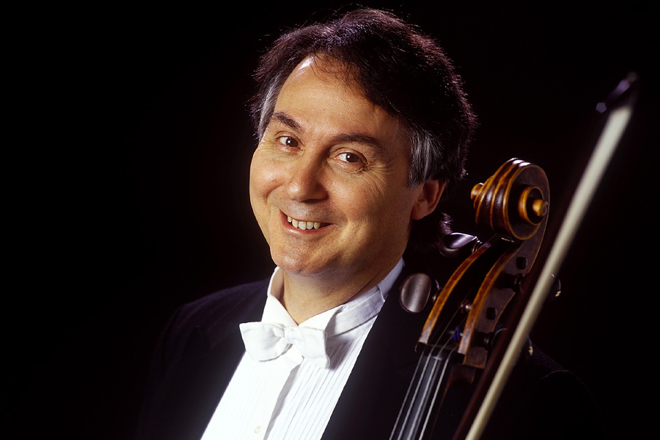 Ralph Kirshbaum wears a dinner jacket and holds his cello, smiling