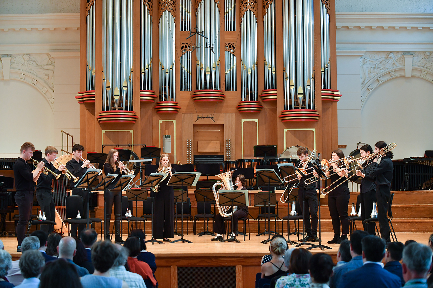 A group of RCMJD students performing on brass instruments on the Concert Hall stage