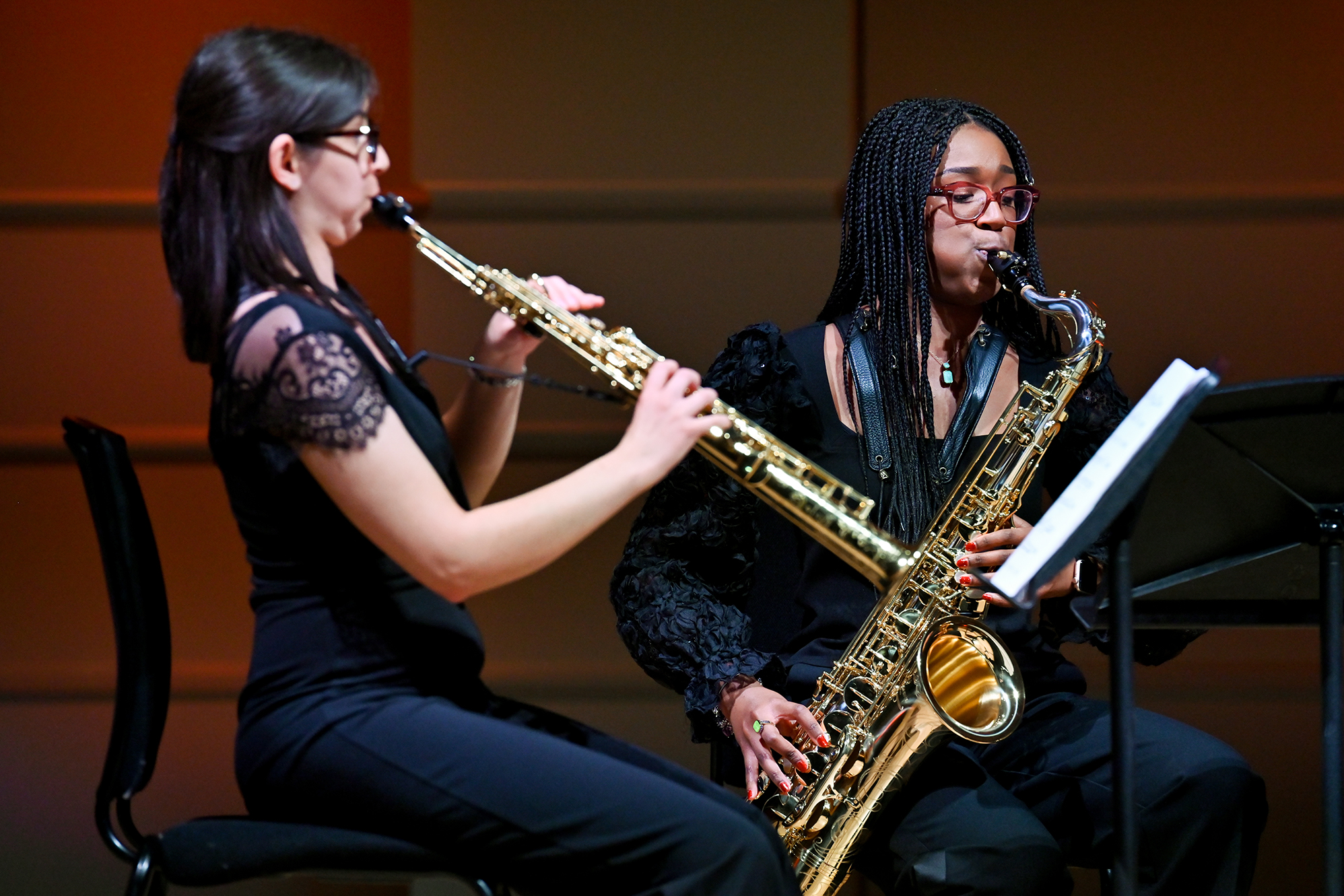 Two saxophonists performing on their saxophones in the RCM Performance Hall
