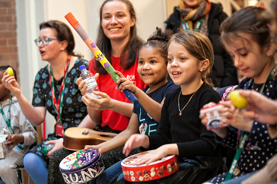 Young children play percussion instruments with RCM Sparks leaders