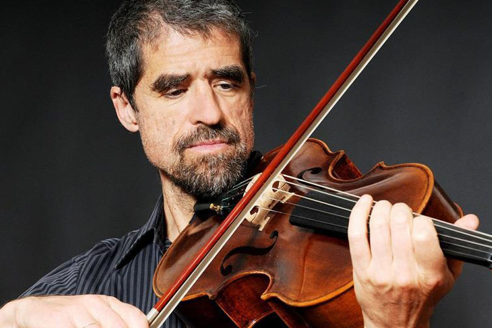 Thomas Riebl plays the viola in a dark room