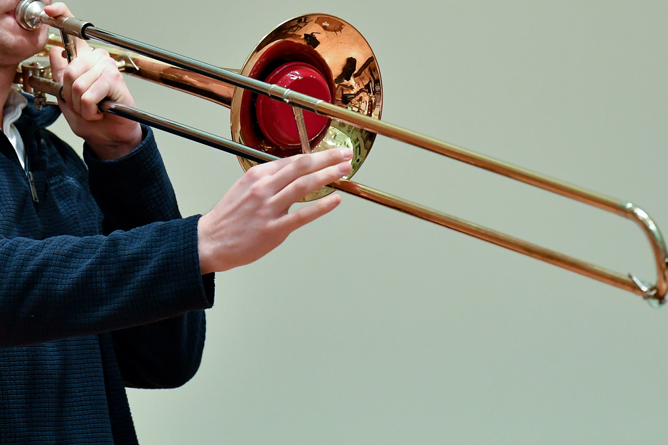 A close-up photo of a performer playing a trombone