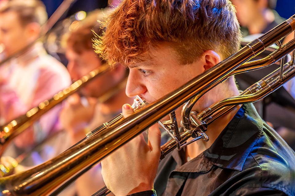 A young man playing the trombone