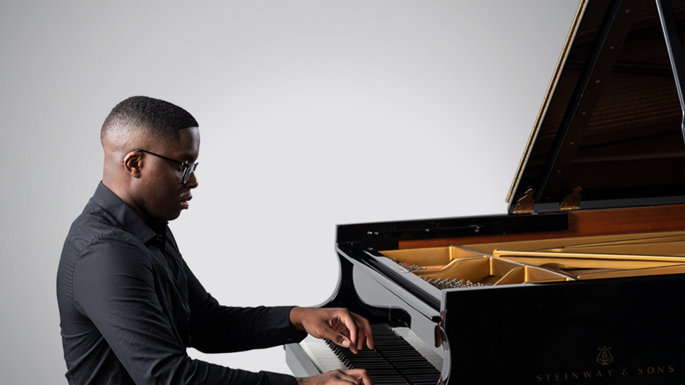 RCM student playing the piano against a silver background