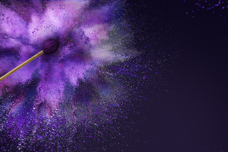 A drumstick surrounded by purple powder, surrounded by a black background.
