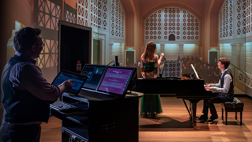 Royal College of Music Centre for Performance Science stage with technician working on the sound, a lady singing and a man playing the piano