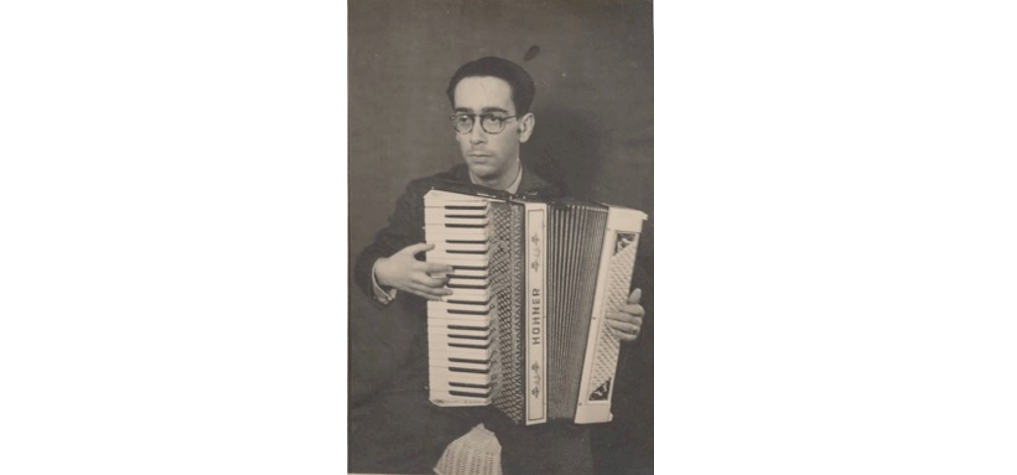 An old photo of a man playing an accordion.